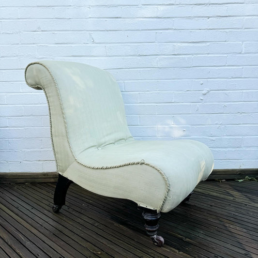 A late 19th century scrolled back slipper chair
